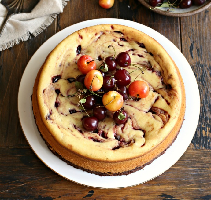 Recipe for cheesecake with a brownie base and cherry preserves swirl.