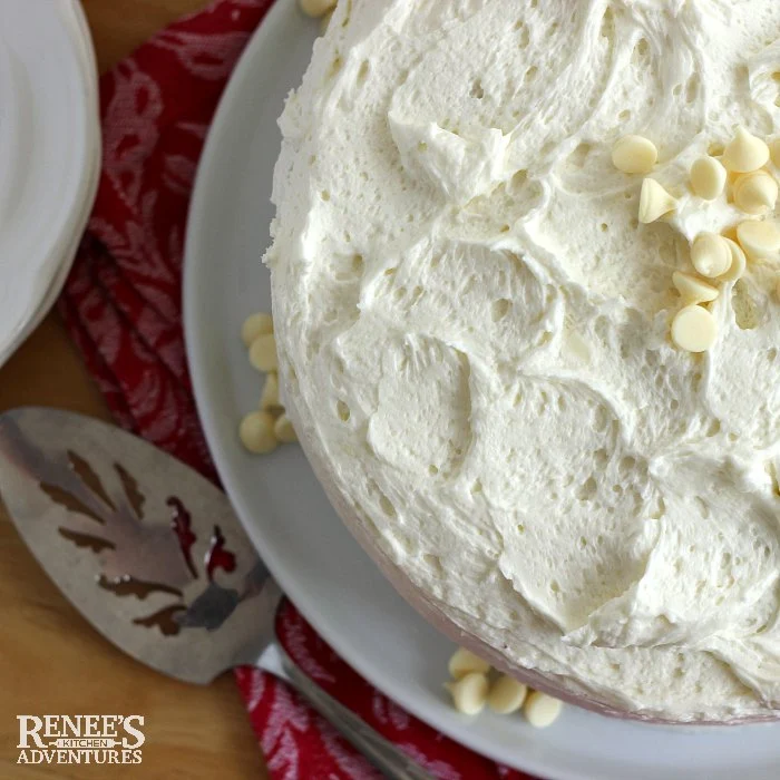 White Chocolate Cake by Renee's Kitchen Adventures overhead view of whole frosted cake with a cake server next to it