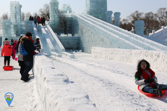 Enjoying the slide on ice sculpture in very cold winter at Harbin Snow Sculpture Art Expo in Heilongjiang province, China Enjoying the slide on ice sculpture in very cold winter at Harbin Snow Sculpture Art Expo in Heilongjiang province, China