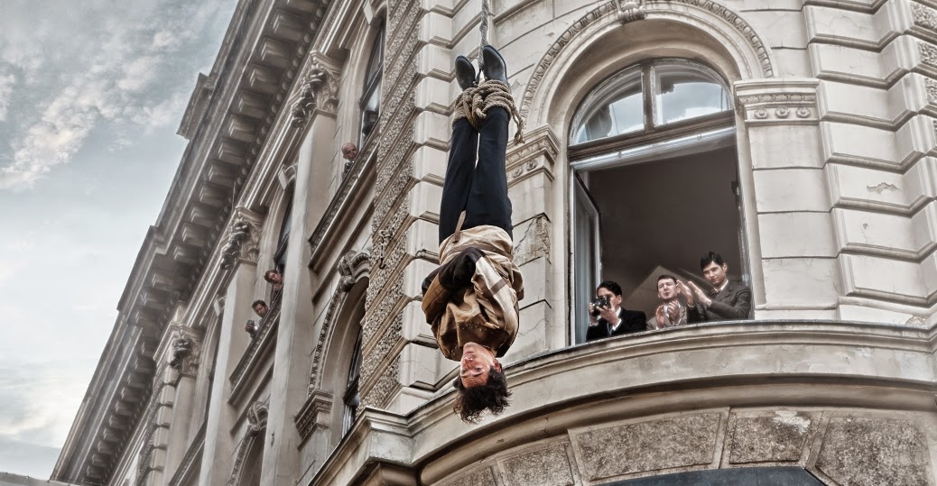 Adrien Brody as Harry Houdini in straitjacket performing a daredevil trick in History Channel TV Mini-Series