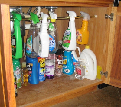 Organizar armário de limpeza com uma barra para pendurar os produtos