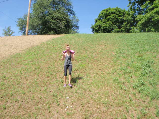 Image of woman walking down a hill with The Ultimate Sandbag on her shoulders