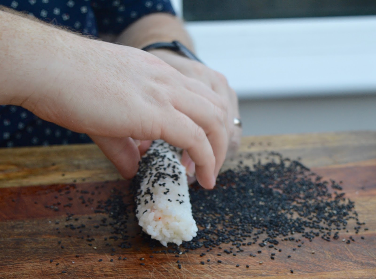 Sushi Making With Kids - A Tutorial for Beginners with Yutaka - coating sushi with sesame seeds