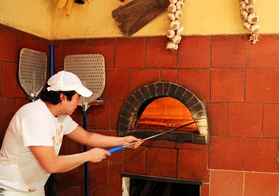 Stock Pictures Cooking pizza in a wood fired brick oven in Italy