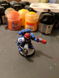 A blue Ultramarine Space Marine Sargent with a brightly contrasting red helm.
