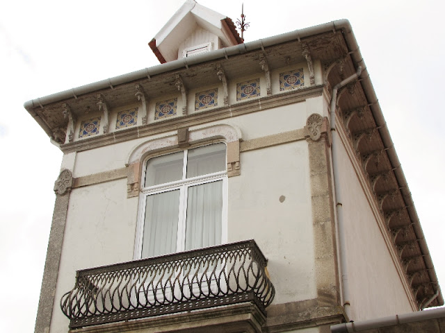 fachada de casa branca com varanda e azulejos próximo do teto