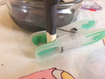 A peg holding a chopstick upright as it's painted