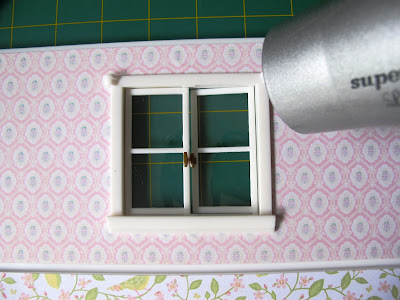 Hairdryer pointed at a window on the wall of a Lundby Smaland dolls' house.