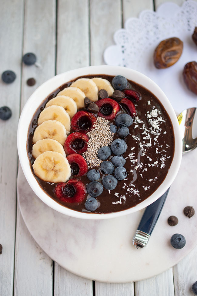 Vegan and gluten-free chocolate date smoothie bowl with fruit toppings