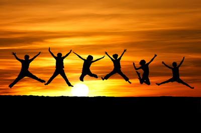 6 people are leaping into the air with the sunset and horizon in the background