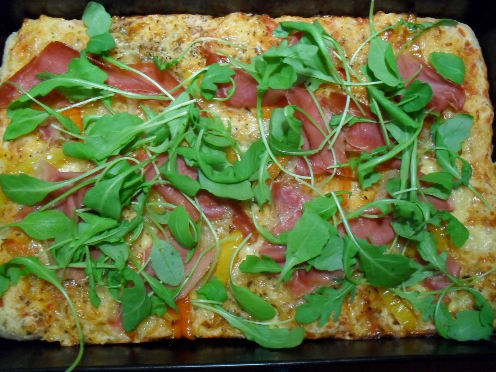 pizza z szynką serrano, rukolą i papryką