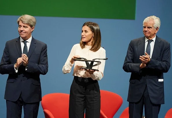 Queen Letizia wore Hugo Boss pink silk blouse and Hugo Boss trousers, and Magrit snake printed pumps, she carried Uterque bag