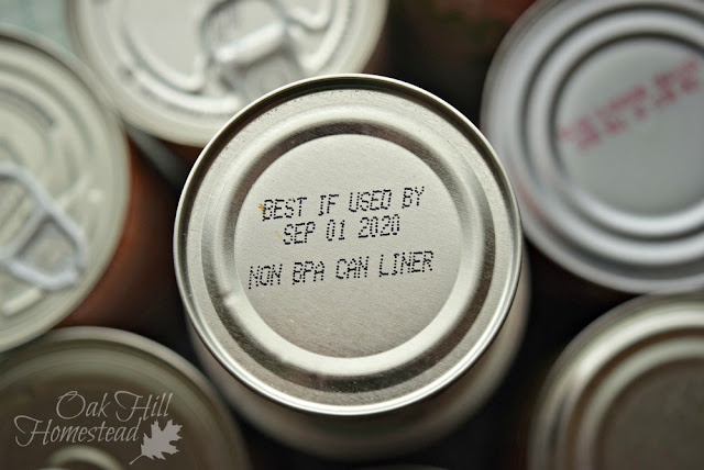 Several cans of food showing expiration dates. An example of a food storage goal.