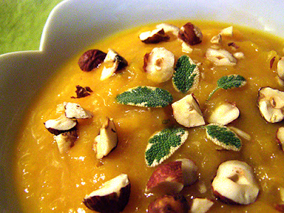 Closeup of soup with hazelnuts and sage leaves