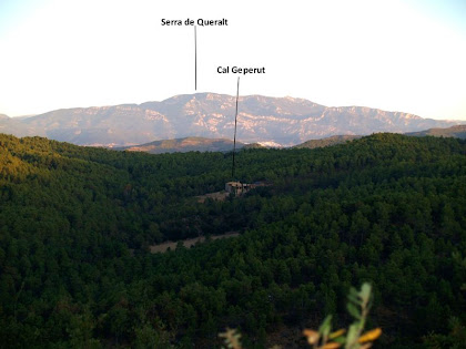 En primer terme Cal Geperut i al fons la Serra de Queralt