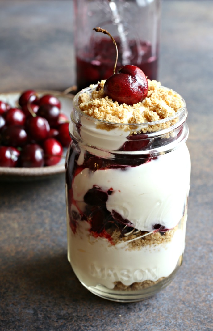 Recipe for no bake cheesecake layered with graham crackers and a cherry compote.
