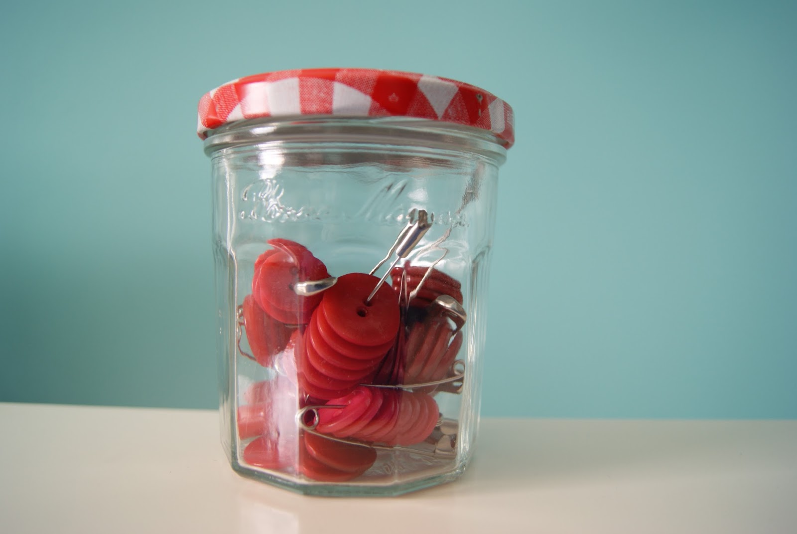 button storage on large safety pins, all same color buttons in one jar by nest full of eggs