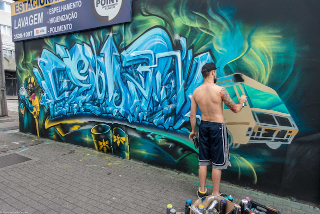 Rapaz pintando grafite em muro