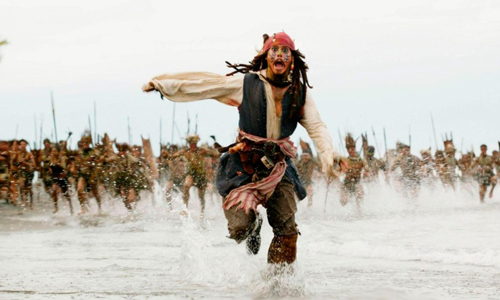 Cena do filmes Piratas do Caribe - O Baú da Morte (2006) onde o Capitão Jack Sparrow aparece fugindo de um bando de selvagens