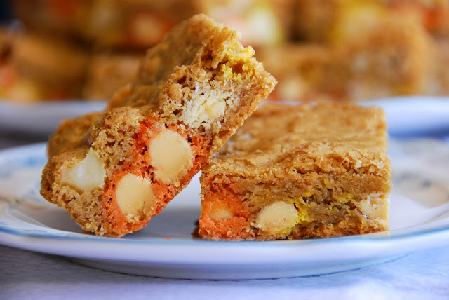 close up of two candy corn M&M, roasted macadamia nut, and sea salt blondies on a small plate