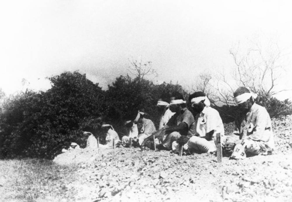 Sikh prisoners sitting in the traditional cross legged prayer position.