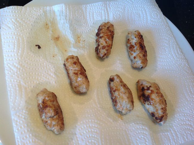 cooked sausages draining on kitchen paper