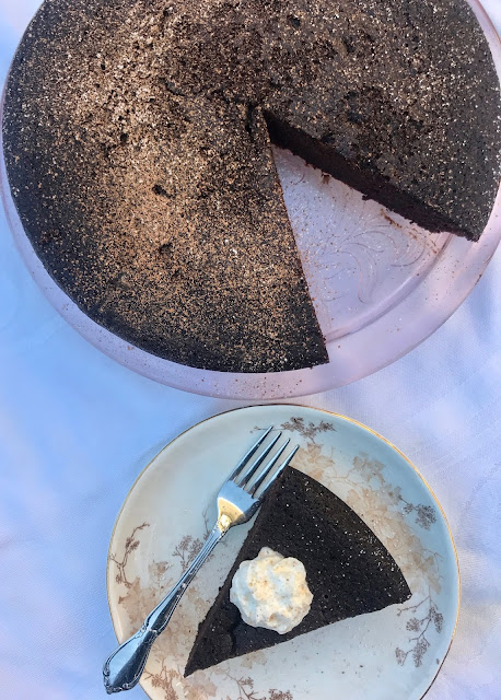 Baked flourless black bean chocolate cake with a piece sliced on a plate.