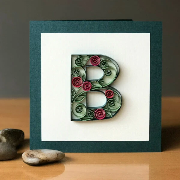 Quilled uppercase letter B filled with quilled flowers on card front