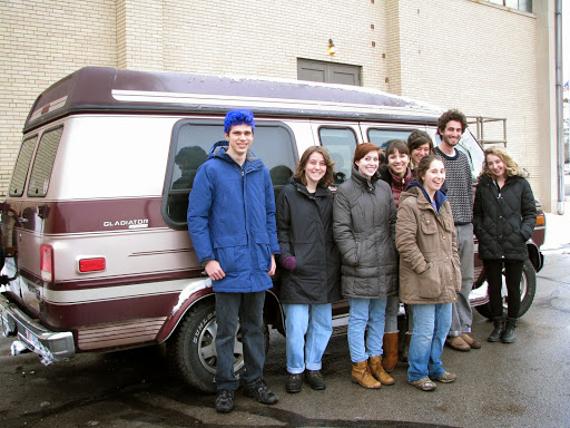 Students pose for the photo in front of a van