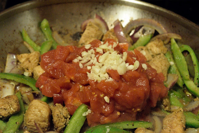 Minced garlic being added to the ingredients in the skillet. 