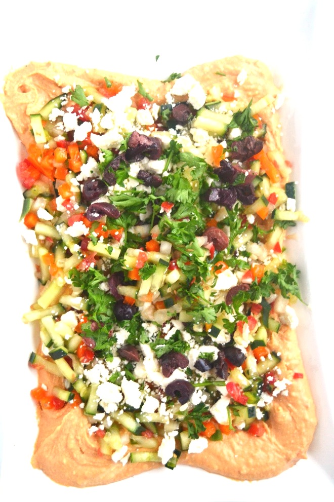 This Mediterranean layered dip features hummus, feta, olives and is loaded with diced vegetables. A quick and flavorful appetizer that no one will know only took you 10 minutes to make! www.nutritionistreviews.com