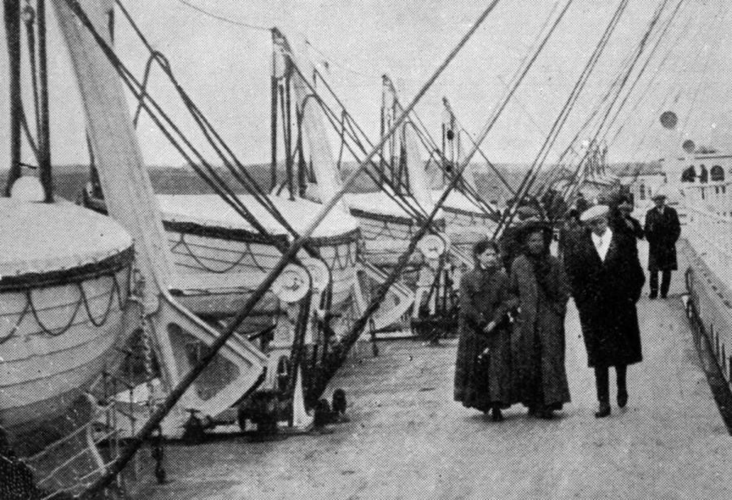Passengers strolling past the lifeboats on the Promenade deck