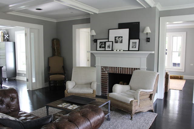 Modern farmhouse decor in living room with fireplace and leather Chesterfield sofa on Hello Lovely Studio