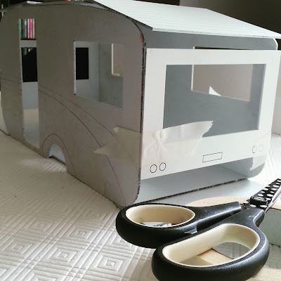 Modern dolls' house miniature retro caravan kit, undercoated and taped together with masking tape.