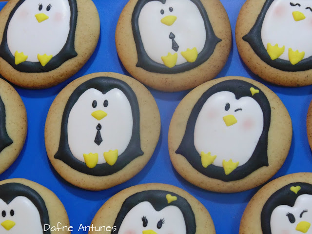 Biscoitos de pinguim decorados com glacê real 