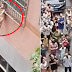 Toddler dangles from metal bars of a three-storey high building