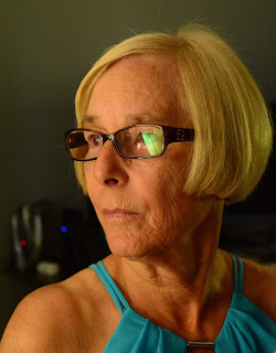 Blond woman with glasses looking away
