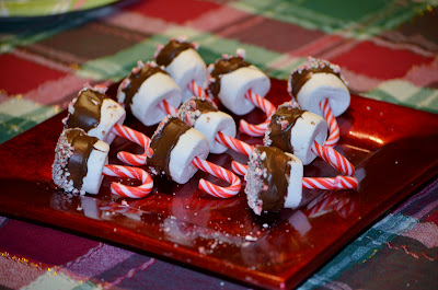 Candy canes in chocolate coated marshmallows dipped in crushed peppermint candies