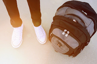 a student's legs and feet with a backpack