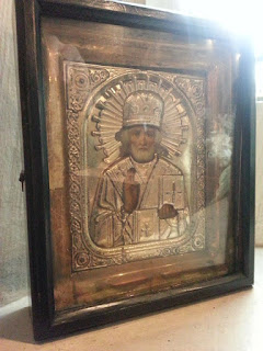 Small highly decorated religious image in wooden frame.
