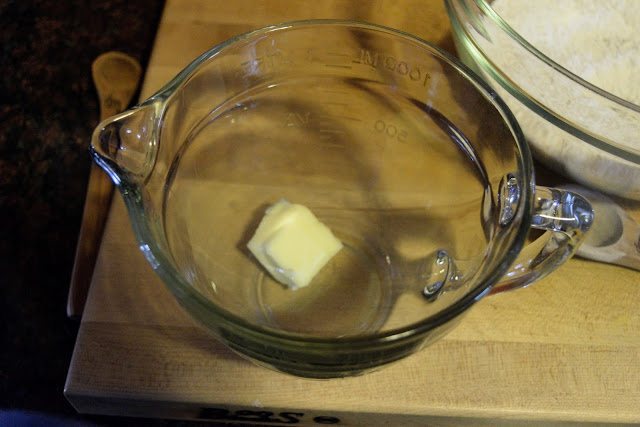 The butter being added to a mixing bowl.