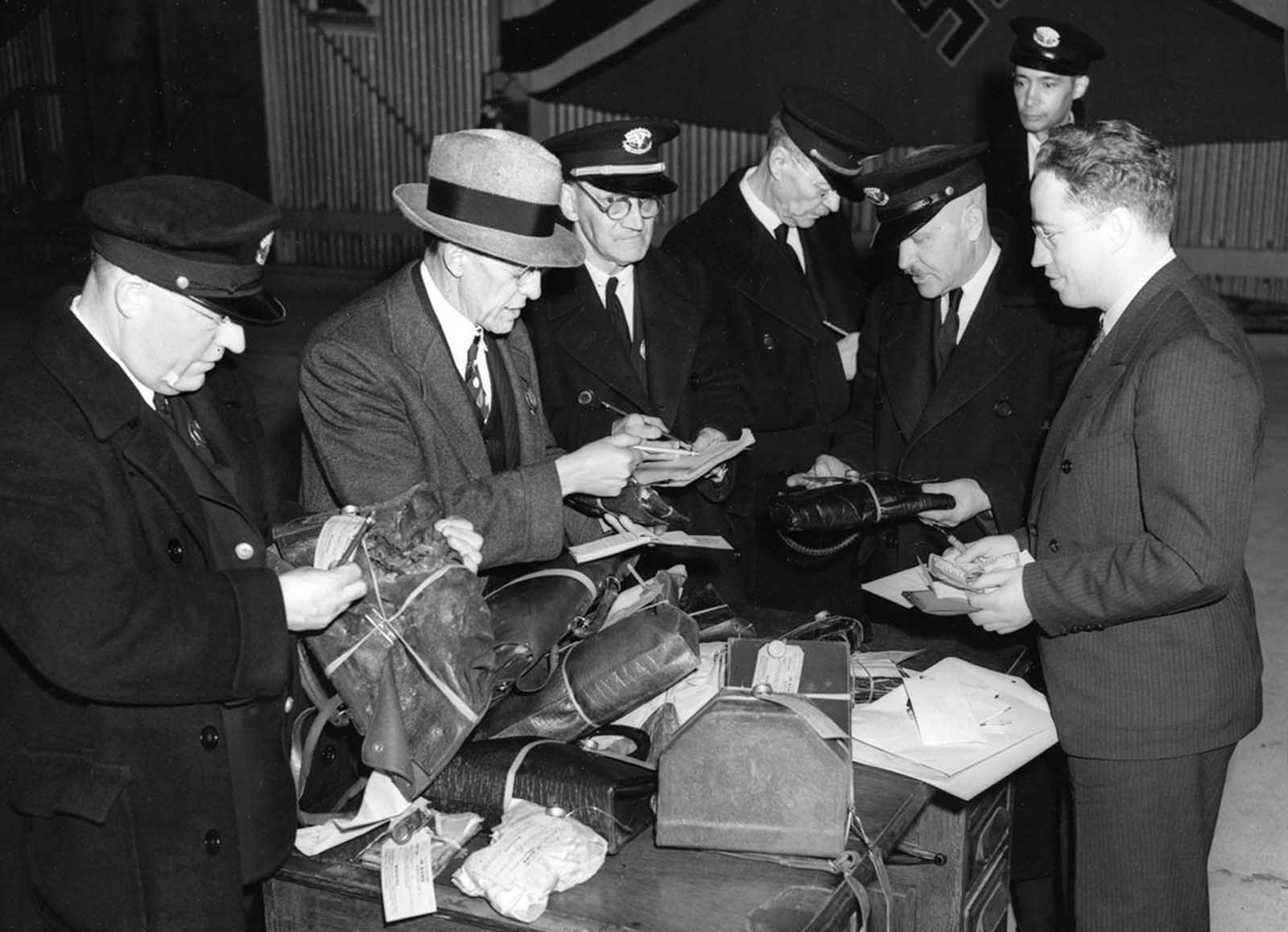 Customs officers search through baggage items salvaged in the Hindenburg explosion in Lakehurst, New Jersey, May 6, 1937.