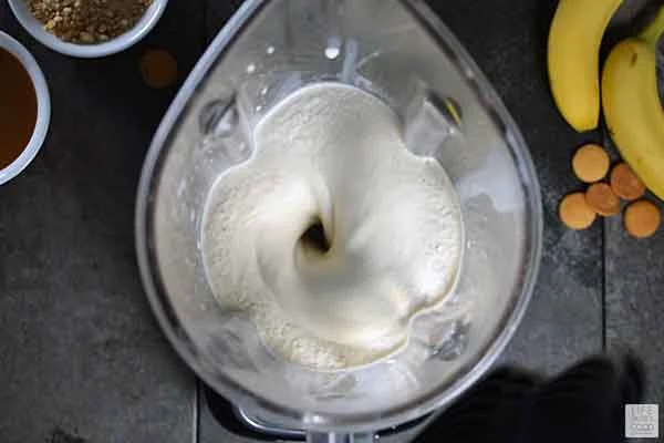 Banana Pudding Milkshake being blended in a blender - top view looking down into blender