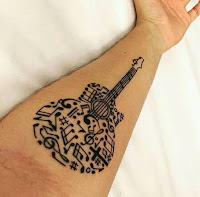 tatuaje de guitarra con notas musicales