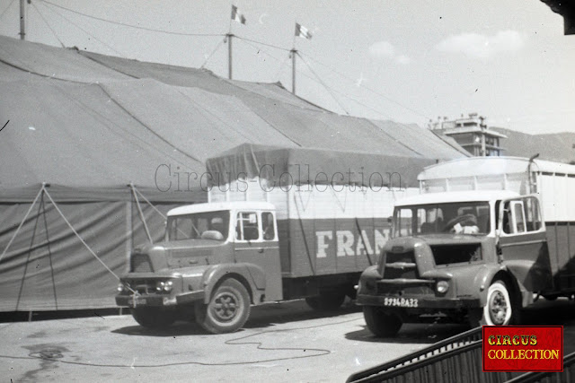 Derrière le chapiteau, deux camions transportant le matériel du Cirque Francki 