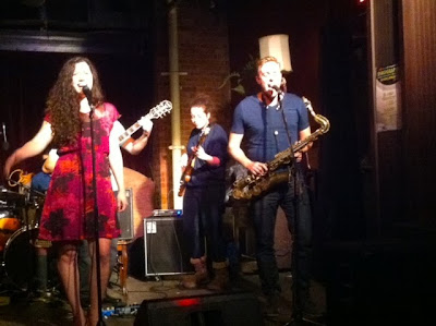 Singer in red dress, bass player and sax player