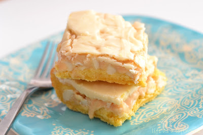 White Chocolate Marshmallow Cake Bars have a yellow cake base, a gooey marshmallow filling and white chocolate chips through out with a white chocolate frosting. Life-in-the-Lofthouse.com
