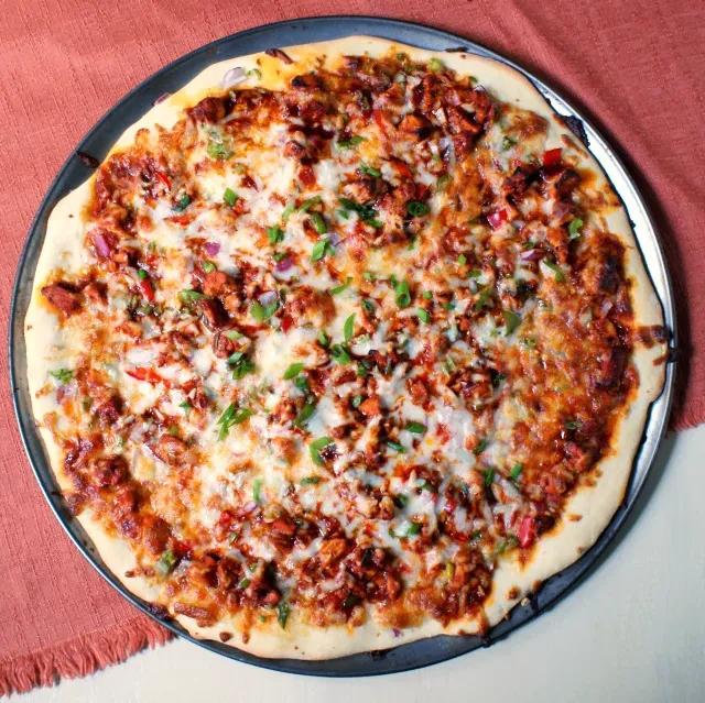 Spicy Kung Pao Chicken Pizza  topped with chicken, fresh veggies, and a hot and spicy sauce.