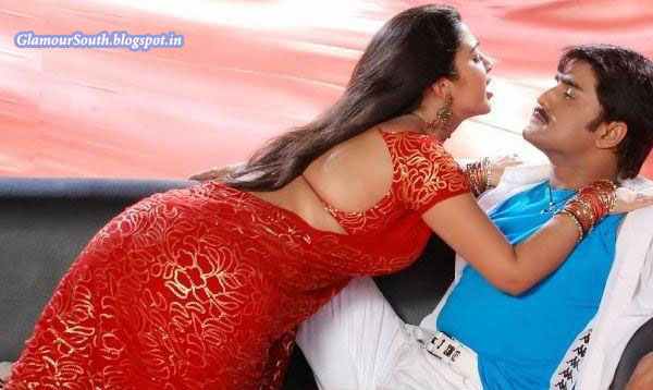 Charmi+Kaur+Hot+Back+in+red+floral+low+hip+saree+with+bare+back+lying+on+top+of+Meka+Srikanth.jpg