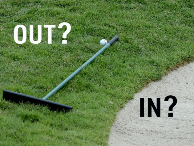 A picture of a rake outside of a bunker, questioning where it should be